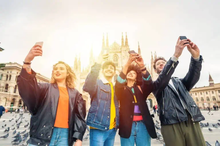 Group of friends tourist taking photos or selfie in front of Milan cathedral